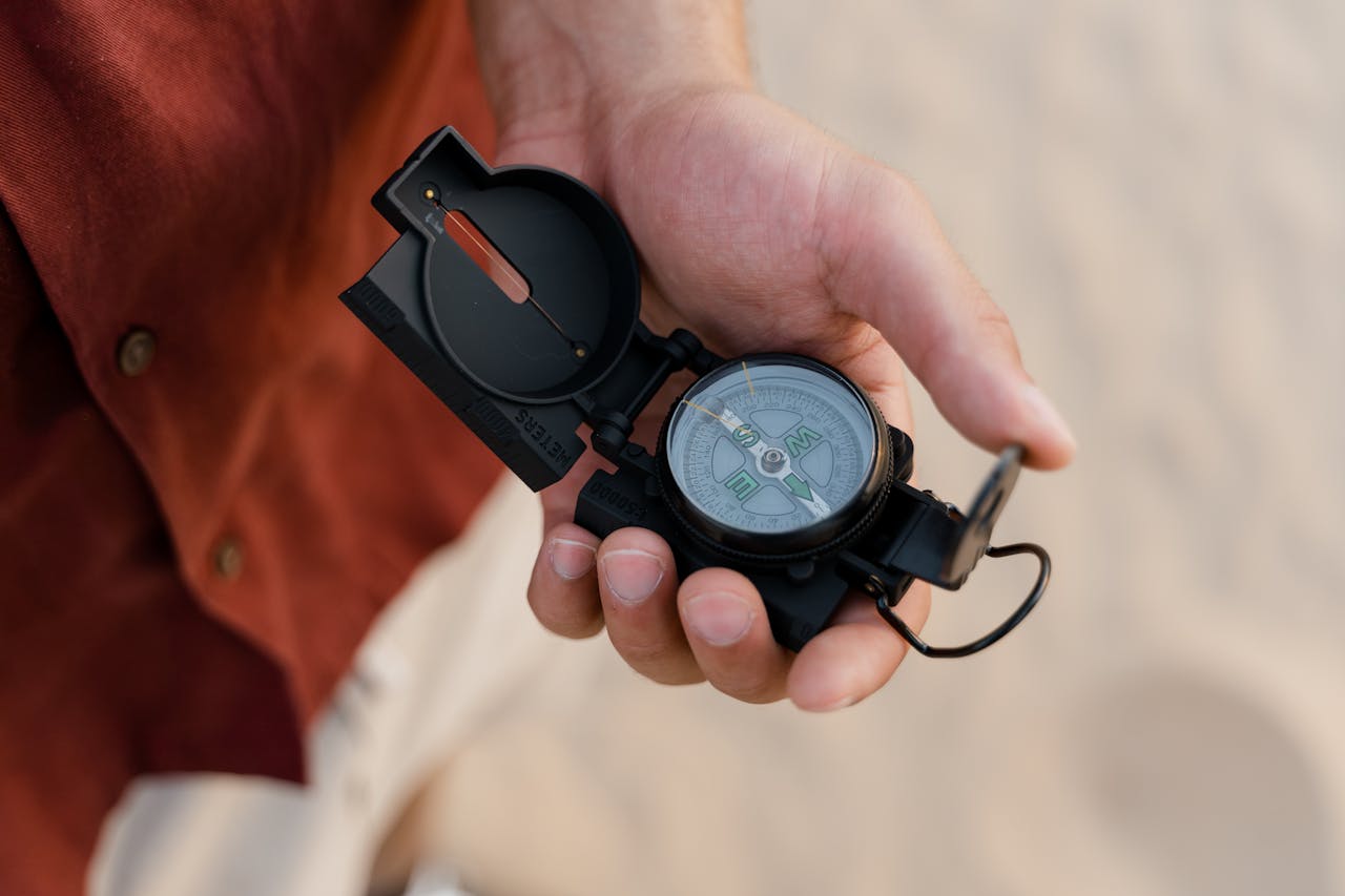 Detailed shot of a person holding a compass in hand, ideal for navigation themes.
